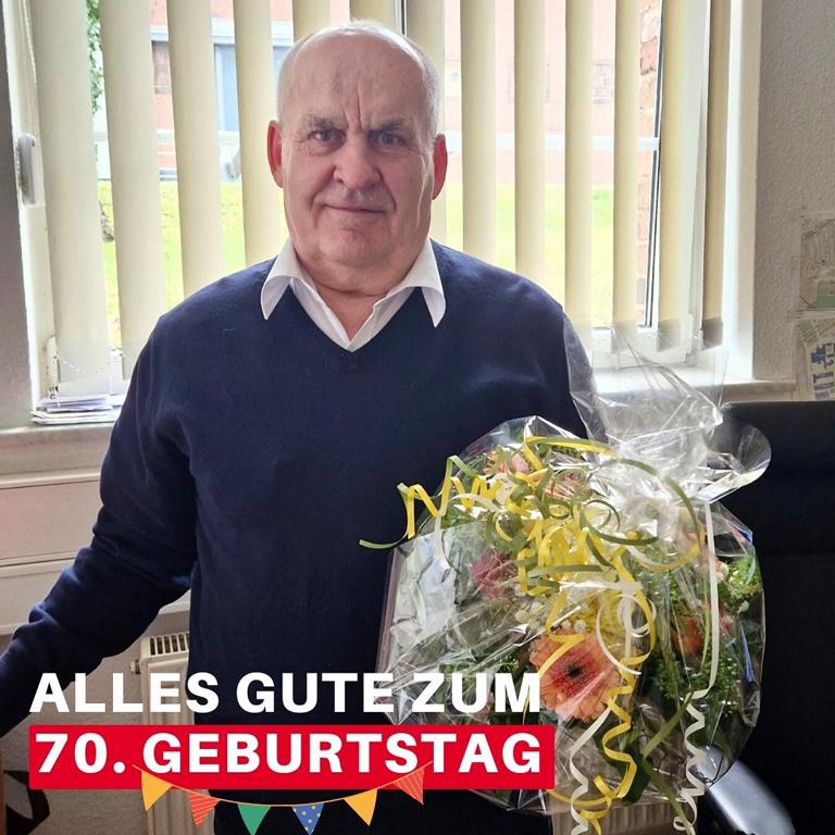 secura protect Mitarbeiter Schmidtgeisler mit großem Blumenstrauß und Aufschrift Alles Gute zum 70. Geburtstag